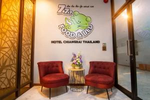 a lobby of a hotel with two chairs and a sign at 777 Food & Bed in Chiang Rai