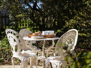 a white table with chairs and a bowl of food on it at Earsdon Cottage in Ireby