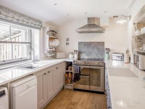 a kitchen with a sink and a stove top oven at Earsdon Cottage in Ireby