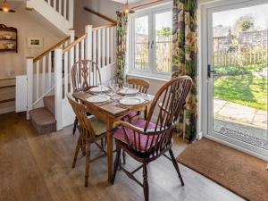 a dining room with a wooden table and chairs at Earsdon Cottage in Ireby