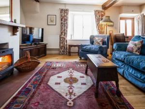 a living room with a couch and a tv at Earsdon Cottage in Ireby