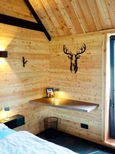 a log cabin bedroom with a deer head on the wall at Chalet Muckelstübchen in Bad Arolsen +18 photos