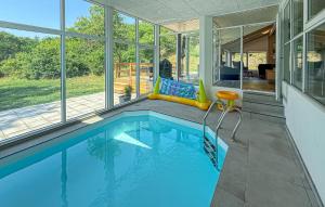 a swimming pool in the middle of a house at Lovely Home In Ebeltoft With Sauna in Ebeltoft