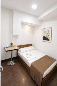 a bedroom with a bed and a desk in it at White Hotel in Yerevan +16 photos