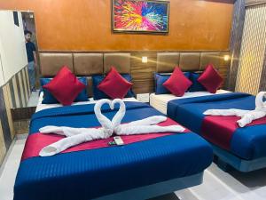 a hotel room with two beds with towels on them at Hotel al raihan in Mumbai