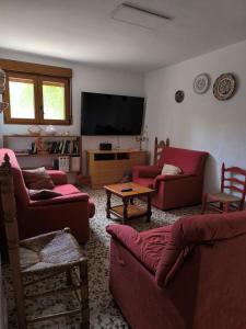a living room with red furniture and a flat screen tv at Pedrera in Banyeres de Mariola