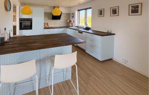 a kitchen with white cabinets and white chairs at Nice Apartment In Hanstholm With Wifi in Hanstholm