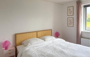 a bedroom with a bed with white sheets and pink lamps at Nice Apartment In Hanstholm With Wifi in Hanstholm