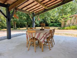 a table and chairs under a wooden pergola at Clos de Beauregard in Cirière