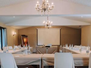 a conference room with tables and chairs and a projection screen at Hotel de L'Abbaye Le Tronchet - Handwritten Collection in Le Tronchet +77 photos