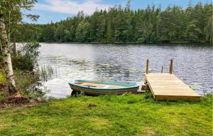 a boat is docked next to a dock on a lake at Amazing Home In Burseryd With Kitchen in Burseryd