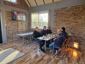 a group of men sitting at a table in a restaurant at Cabañas El Sauce in Albardón