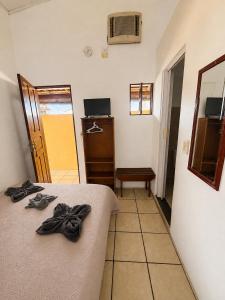 a bedroom with a bed and a dresser and a door at Pousada Gire in Itacaré
