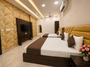 a bedroom with two beds and a flat screen tv at Hotel KR Near Golden Temple in Amritsar