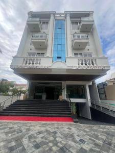 a large white building with a red carpet in front at L G Cordial in Mysore