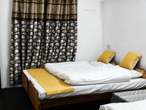 a bed in a room with a curtain at Hotel Dharali Nature In Dharali in Gangnāni +19 photos