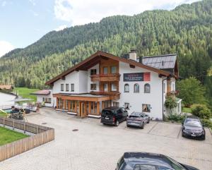 a large building with cars parked in a parking lot at Soliva Hotel & Apartments by MEIN SAMNAUN - MOUNTAIN HOMES in Samnaun