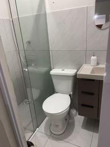a bathroom with a toilet and a shower and a sink at Pousada Coral in Osório