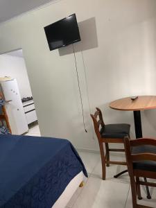 a bedroom with a table and a bed and a table and chair at Pousada Coral in Osório