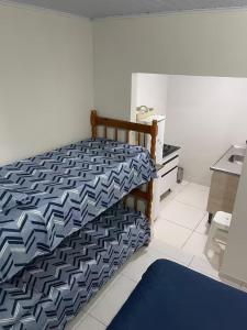 a bedroom with a bed with a blue and white bedspread at Pousada Coral in Osório