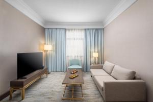 a living room with a couch and a flat screen tv at Grand Millennium Al Haram Hotel in Medina