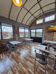 a room with tables and chairs and windows at Cabañas El Sauce in Albardón