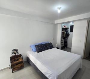 a white bedroom with a bed and a closet at Conjunto Torres del Bosque-diagonal a la Foscal in Floridablanca