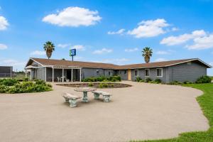 a building with two benches in front of it at Valley Motel Corpus Christi Near Airport I 37 in Corpus Christi