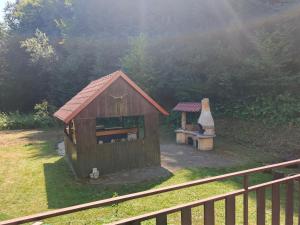 a small building with a bench in a yard at Chata Moniela in Drietoma +2 photos