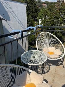 two chairs and a table on a balcony at Herz Apartmani in Igalo