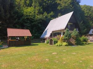 a large house with a metal roof and a gazebo at Chata Moniela in Drietoma