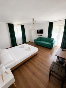 a living room with a bed and a green couch at La Luca in Maliuc