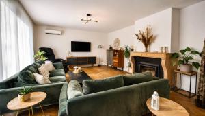 a living room with two green couches and a fireplace at Le Bosquet-Villa Prestige, Parking privé, Jardin, Wifi in Lys-lès-Lannoy