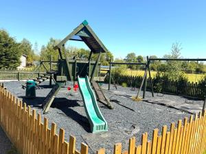 a playground with a green slide in a park at Glamping Hut - Sleeps 2 hot tub & parking in Welshpool +13 photos
