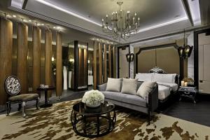 Taichung Ease Motel في Taiping: غرفة نوم بسرير واريكة وثريا