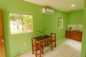 a kitchen with green walls and a table and a window at Complejo de Apartamentos parque naturaleza in Encarnación