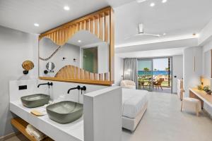 a bathroom with a sink and a bed and a mirror at Ventale Island Breeze Resort in Georgioupolis