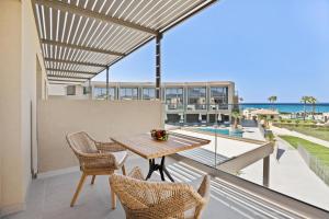 a patio with a table and chairs and a view of the ocean at Ventale Island Breeze Resort in Georgioupolis