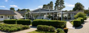 a large building with bushes in front of it at Åhus Havsvillor in Åhus