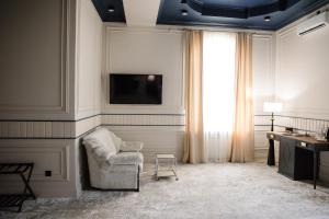 a living room with a chair and a television at Lumen in Kostanay