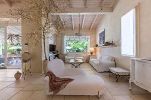 a large living room with white furniture and a tree at Villa Reginella - Rive del Salento in Lecce