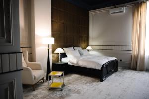 a bedroom with a king sized bed and a chair at Lumen in Kostanay