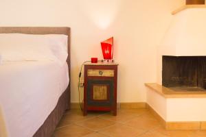 a bedroom with a bed and a fireplace at Solemar Sicilia - Le Casette Di Calzata in Campofelice di Roccella