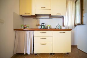 a kitchen with white cabinets and a sink at Solemar Sicilia - Le Casette Di Calzata in Campofelice di Roccella +113 photos