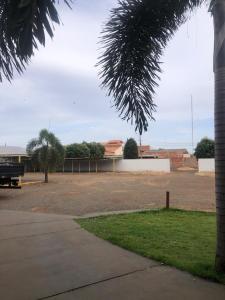 a parking lot with a park with a bench and a building at Primeiro Hotel in Ilha Solteira