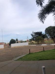a parking lot with a fence and a field at Primeiro Hotel in Ilha Solteira +1 photo
