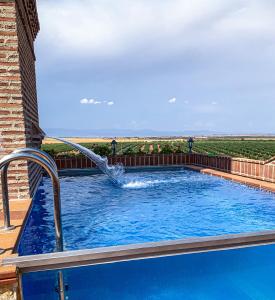 a swimming pool with a water fountain at Spa Complejo Rural Las Abiertas in San Bartolomé de las Abiertas