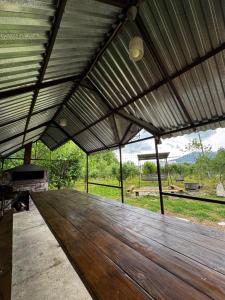 a wooden table in a pavilion with a view of a field at BUJAKAN EcoTourism in Buzhakan