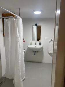 a white bathroom with a sink and a mirror at Old Town Hotel Dhermi in Dhërmi +26 photos