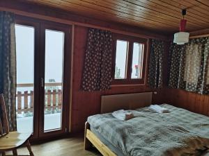 a bedroom with a bed in a room with windows at Chalet Bisse Neuf in Saint-Luc